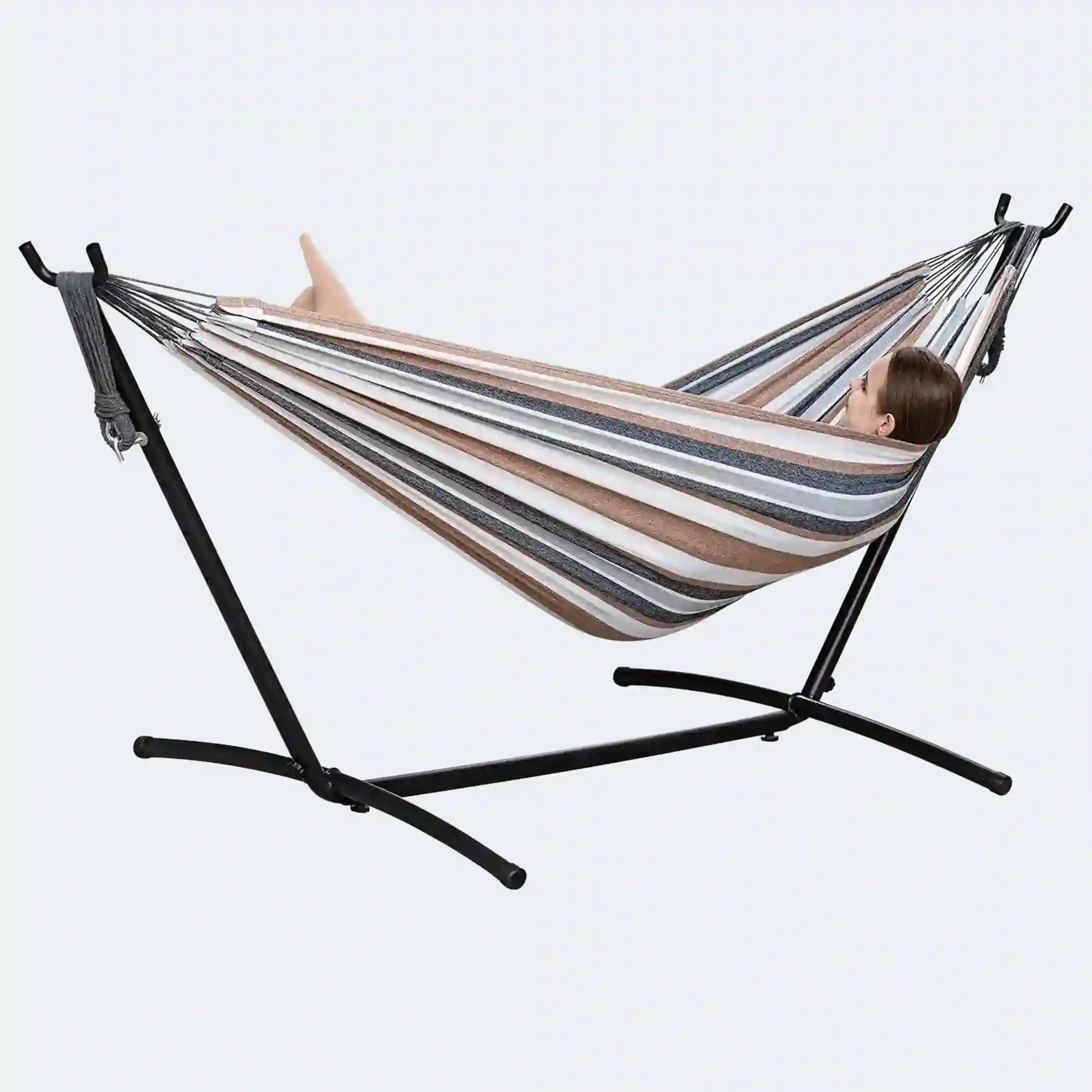 Hamaca de tela a rayas en tonos marrón, blanco y gris, sostenida por una estructura metálica negra, con una persona recostada descansando.