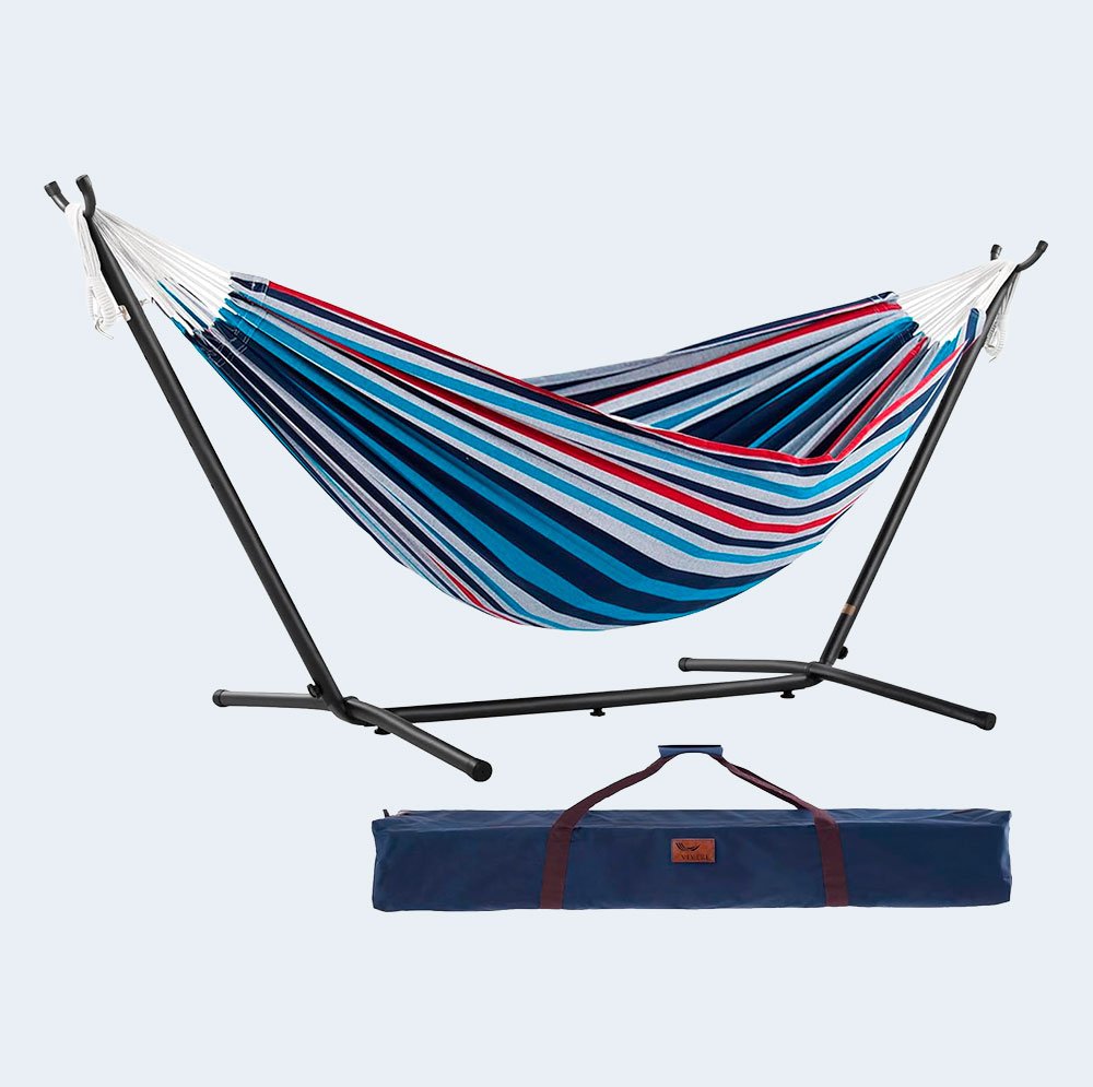 Hamaca de rayas azul, roja y blanca con soporte metálico negro y bolsa de transporte azul.